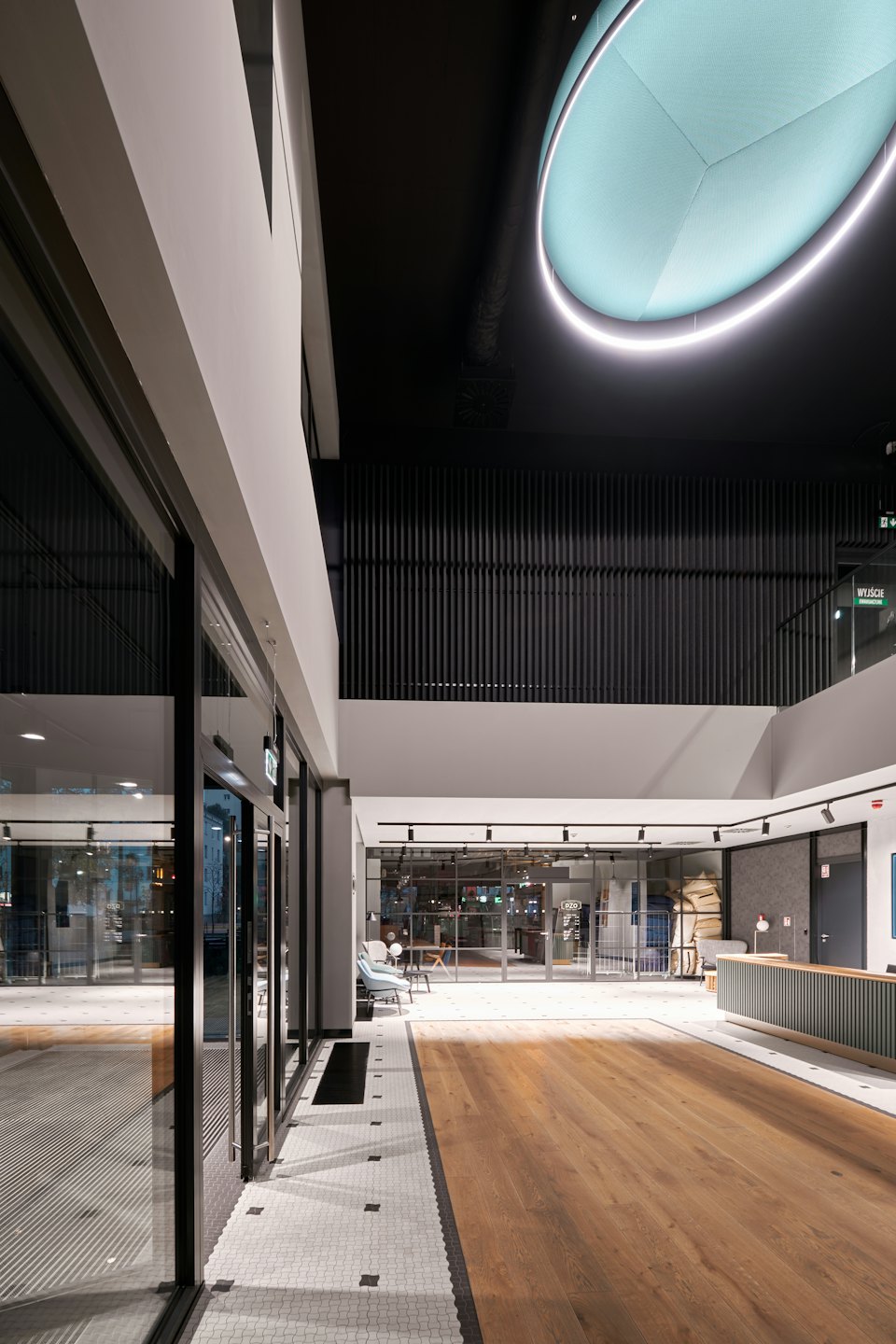 Modern building lobby with wood floor and hexagonal tile path.